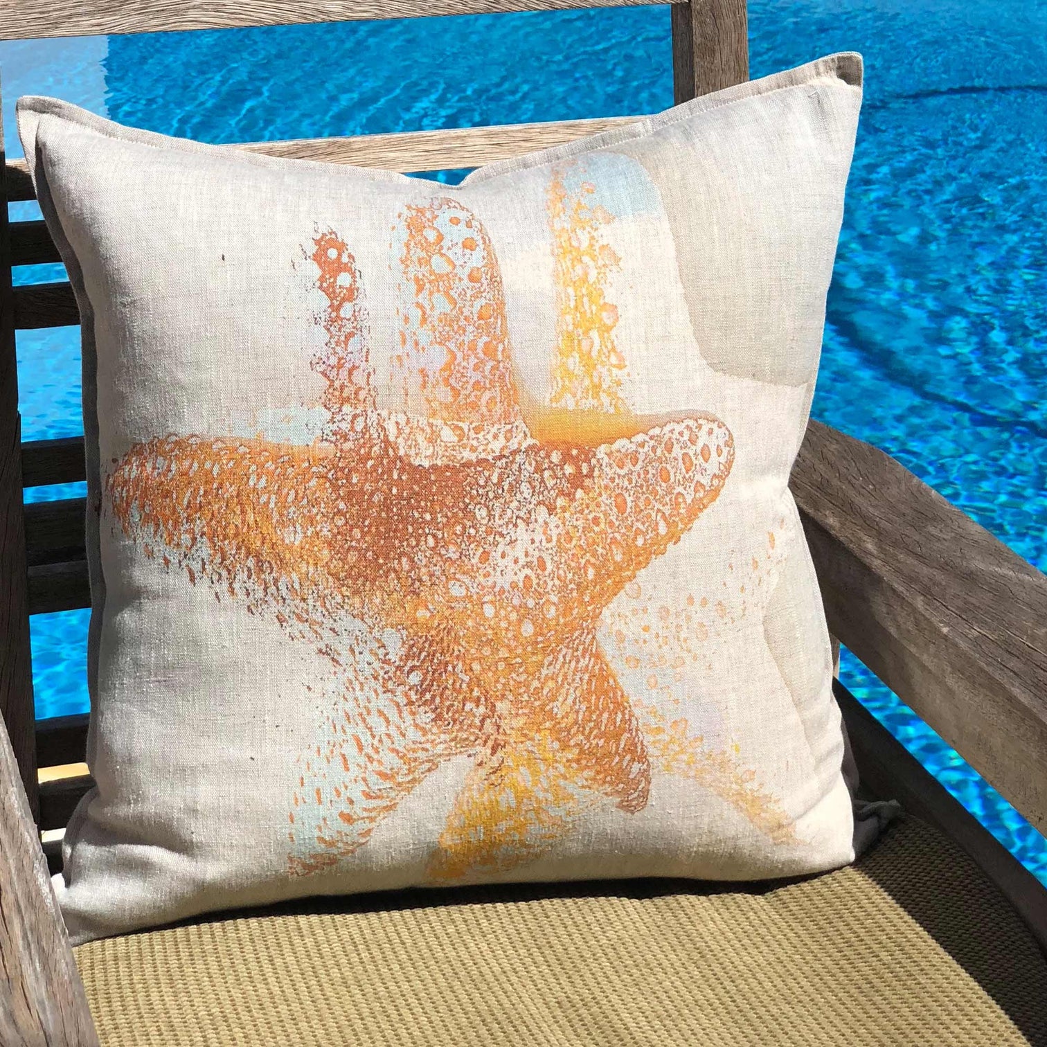 Tinks starfish print cushion in soft coastal tones styled in a sunlit interior
